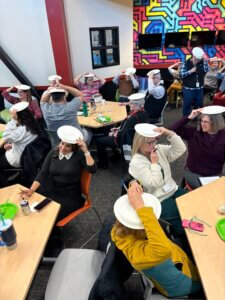 A group of people holding plates over their head for a group icebreaker activity